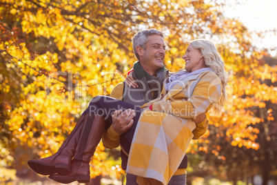 Happy man carrying woman at park