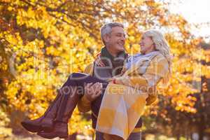 Happy man carrying woman at park