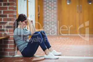 Stressed mature student sitting in locker room