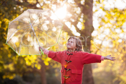 Smiling girl holding umbrella at park