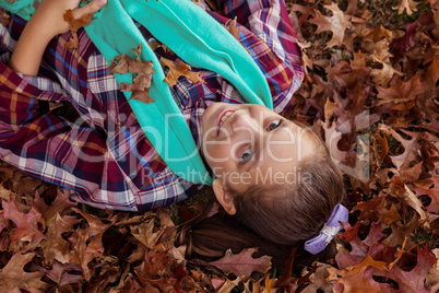 High angle portrait of smiling girl lying at park