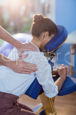 Physiotherapist giving shoulder massage to a female patient