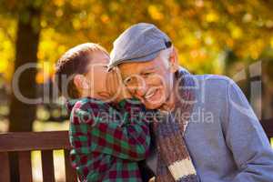 Grandson whispering to grandfather