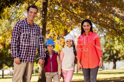 Portrait of happy family holding hands at park