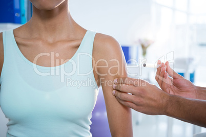 Physiotherapist injecting female patient