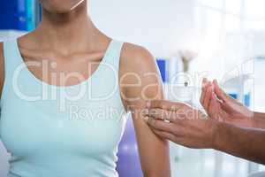 Physiotherapist injecting female patient