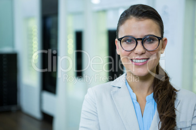 Optometrist in spectacles smiling in optical store