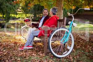 Couple relaxing on bench at park