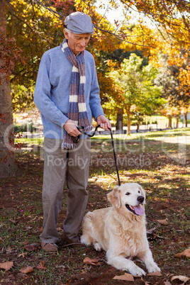 Elderly man keeping his dog on a lead