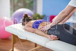 Male physiotherapist giving back massage to female patient