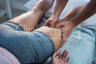 Physiotherapist giving leg massage to a woman