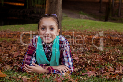 Portrait of smiling girl lying at park