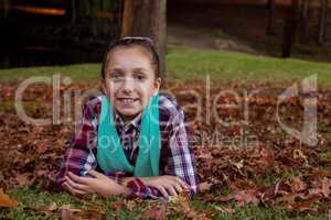 Portrait of smiling girl lying at park