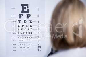 Optometrist looking at eye chart