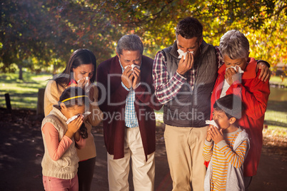 Family blowing nose while in park