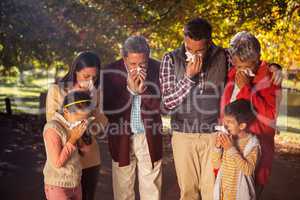 Family blowing nose while in park