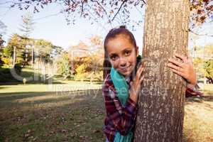 Portrait of happy girl hugging tree