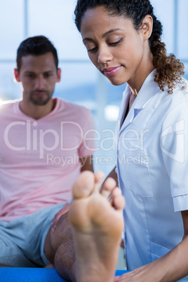 Physiotherapist giving leg massage to a man