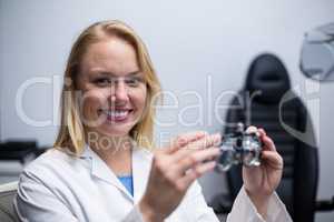 Smiling female optometrist holding messbrille