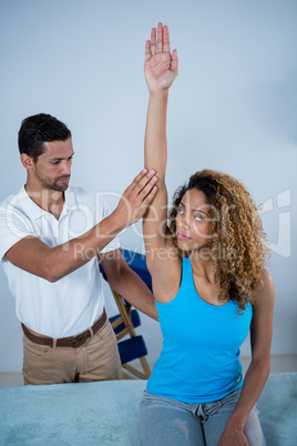 Physiotherapist giving arm massage to female patient