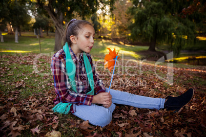 Girl blowing pinwheel in park during autumn