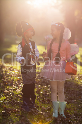 Happy siblings wearing costumes at park