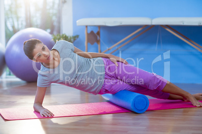 Woman performing exercise using foam roll