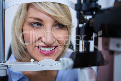 Female patient under going eye test on slit lamp