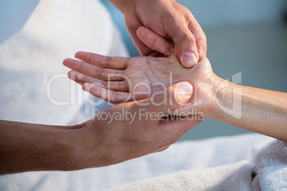 Physiotherapist giving hand massage to a woman