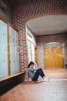 Stressed mature student sitting in locker room