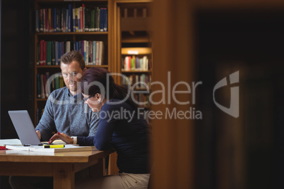 Mature students working together in college library