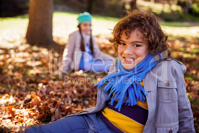Portrait of cheerful by sitting on field in park