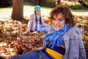 Portrait of cheerful by sitting on field in park