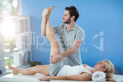 Male physiotherapist giving knee massage to female patient