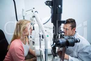 Optometrist examining female patient on coreometry