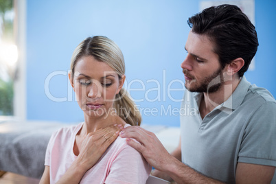 Physiotherapist massaging shoulder of a female patient