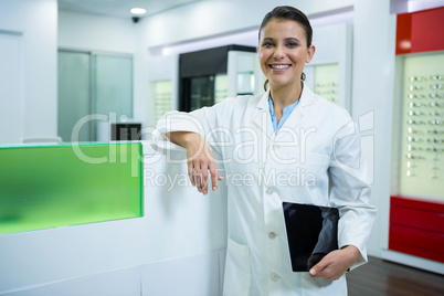 Optometrist holding digital tablet in optical store