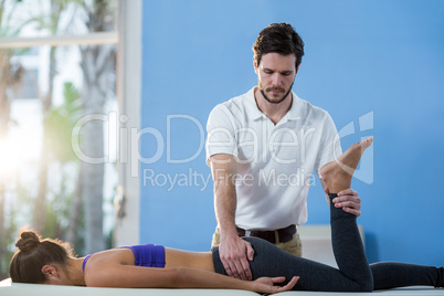 Male physiotherapist giving knee massage to female patient