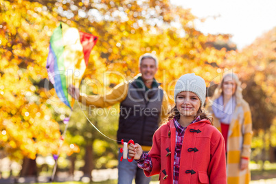 Cheerful girl playing with kite at park