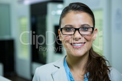 Optometrist in spectacles smiling in optical store