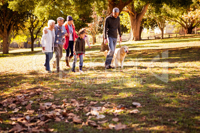 Smiling family walking with their dog