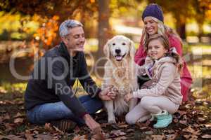 Family sitting with dog at park