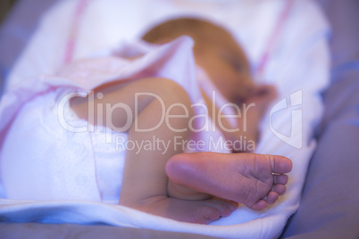 Close-up of a newborn foot baby girl sleeping