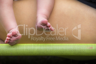 Newborn feet with mother leg background on green bar