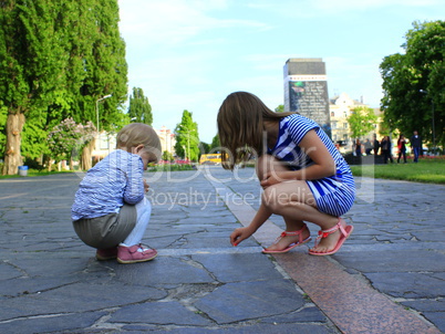 little sisters write on the road in the park