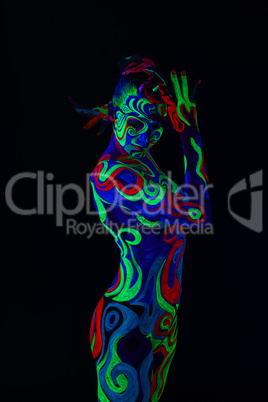 Girl with body art glowing in ultraviolet light