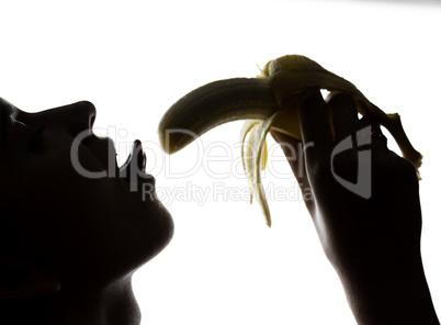 Close-up of Young amazed woman holding a banana, she is going to eat a banana. she sucks a banana