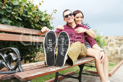 Young beautiful couple with message "Just married" in his shoes.