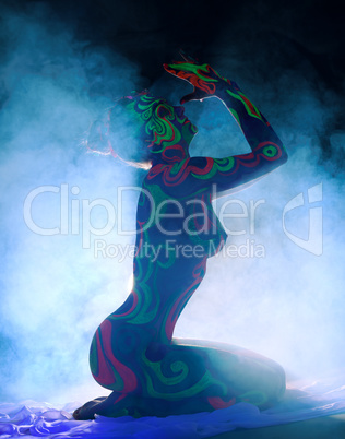 Side view of nude girl with body art in smoke