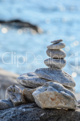 Zen stones against blue sea bokeh